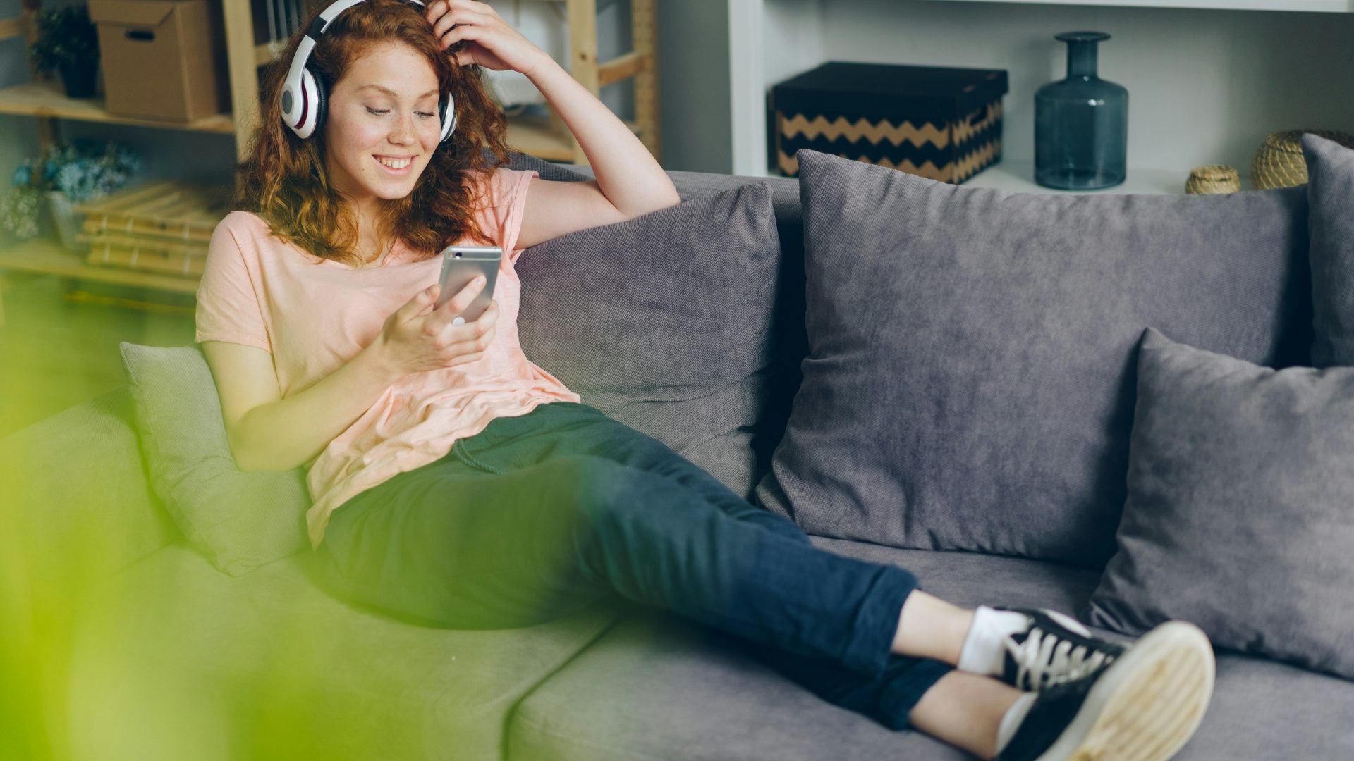 a woman sitting on a couch listening to music